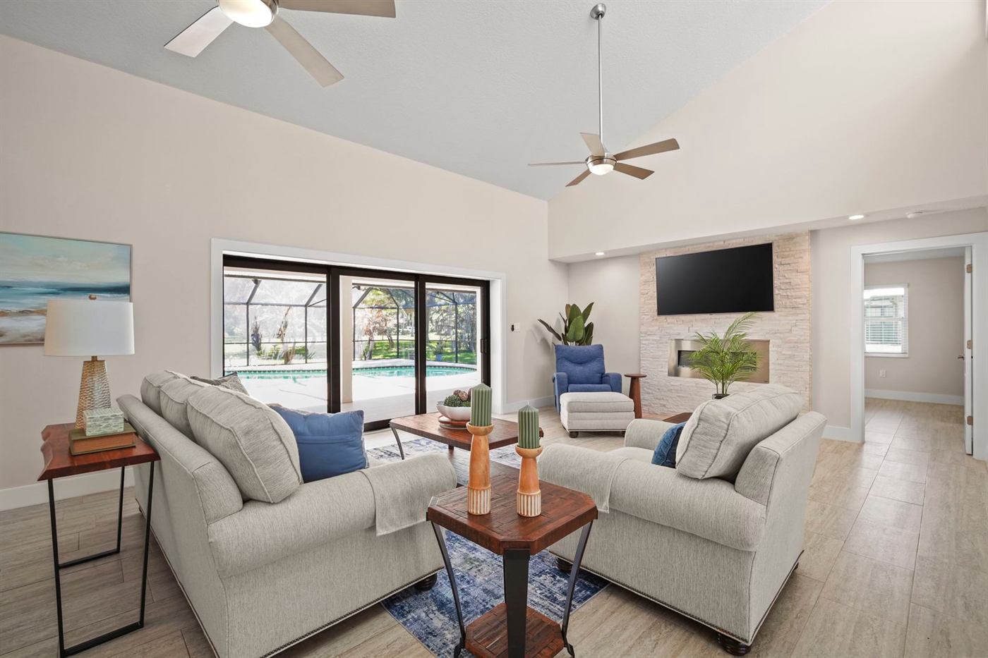 Living room with vaulted ceilings opening to a screened pool